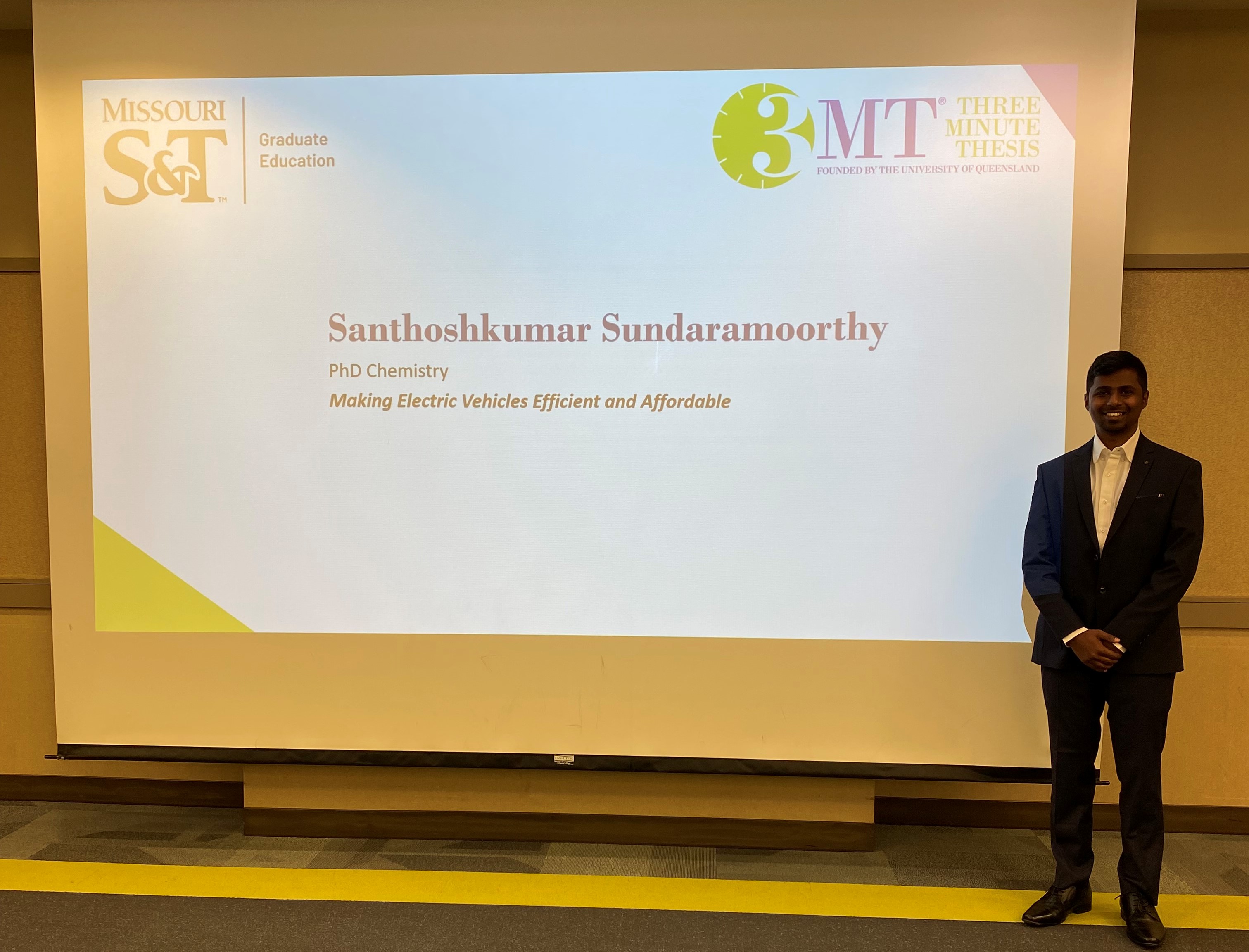 Graduate student Santhoshkumar Sundaramoorthy stands in front of his slideshow presentation on 